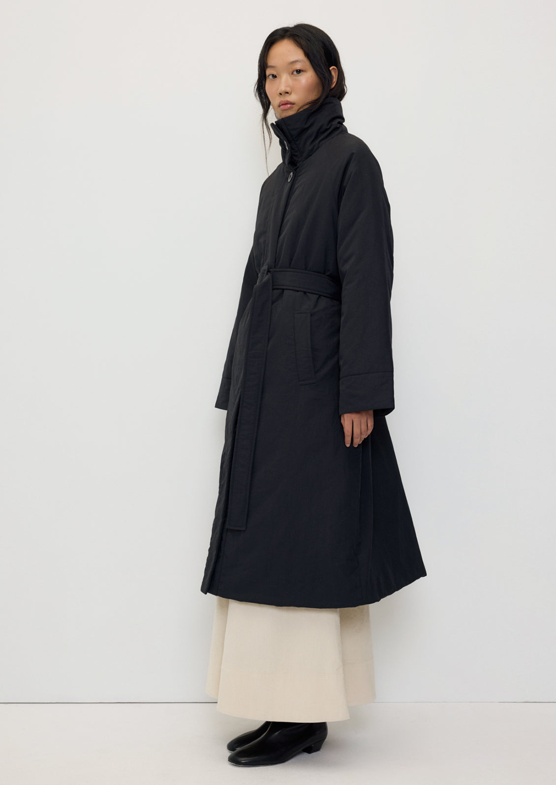 Tender Jacket in Black by Rita Row — three-quarter view belted at the waist over a long cream skirt