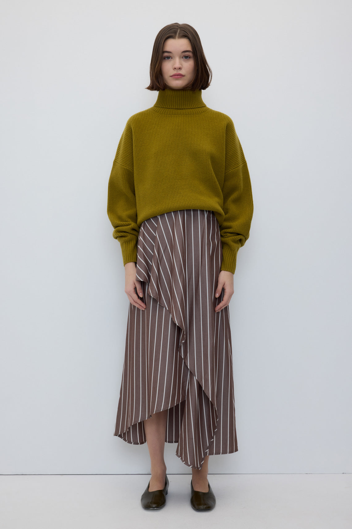 Emma Skirt in Brown Stripes by Rita Row — full-length front view of the brown pinstripe midi wrap skirt, worn with an olive turtleneck