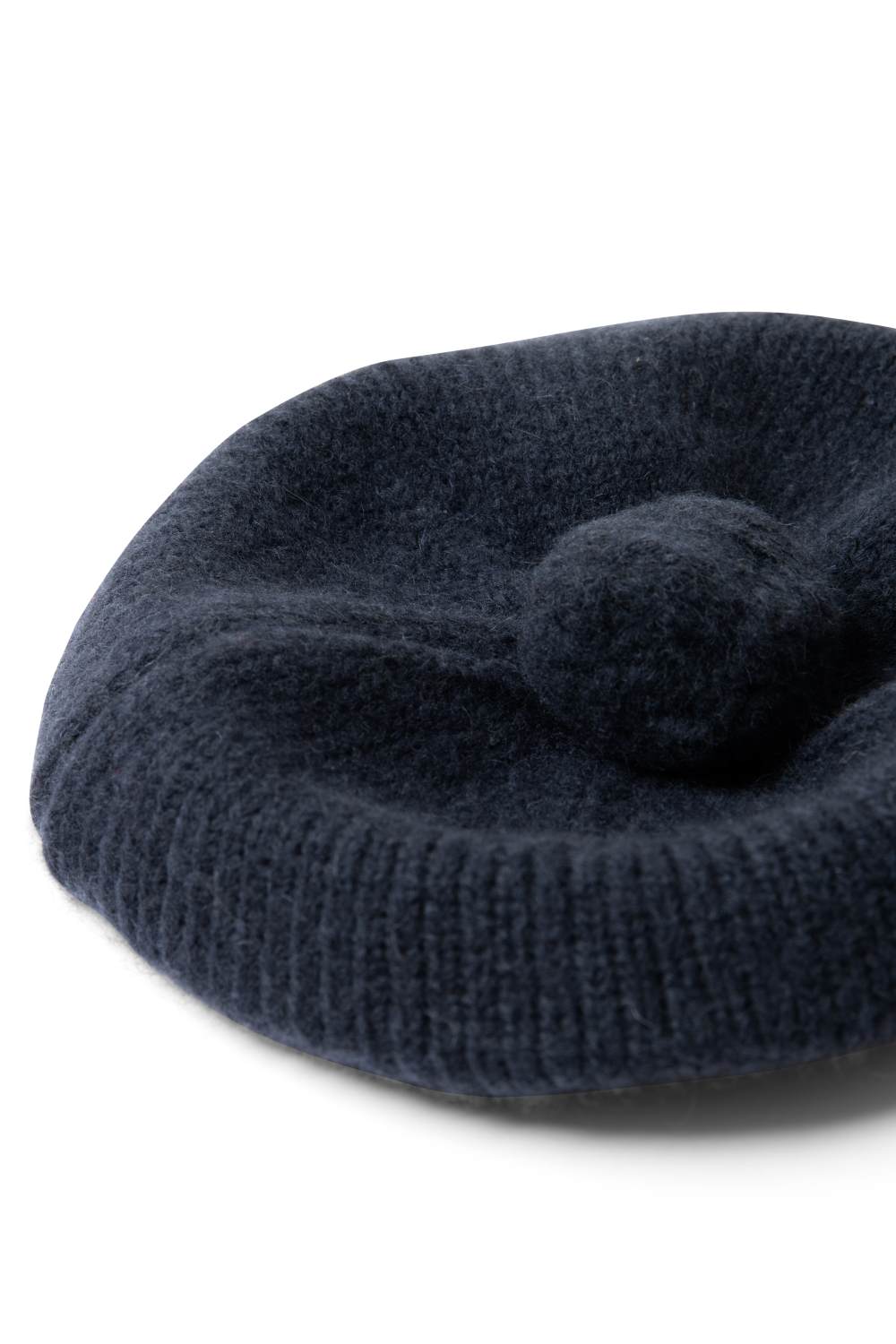 Knitted Pom Pom Beret in Navy, angled product view showing the pom pom