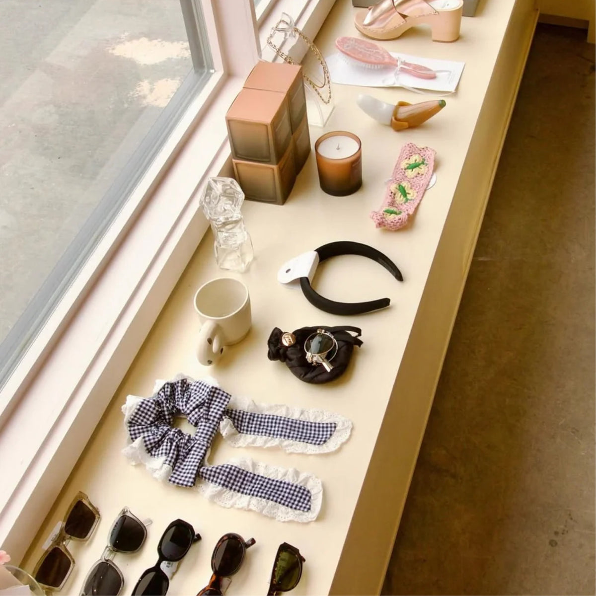 Jewelry, hair clips and candles displayed by the window at Dear Neighbor Richmond