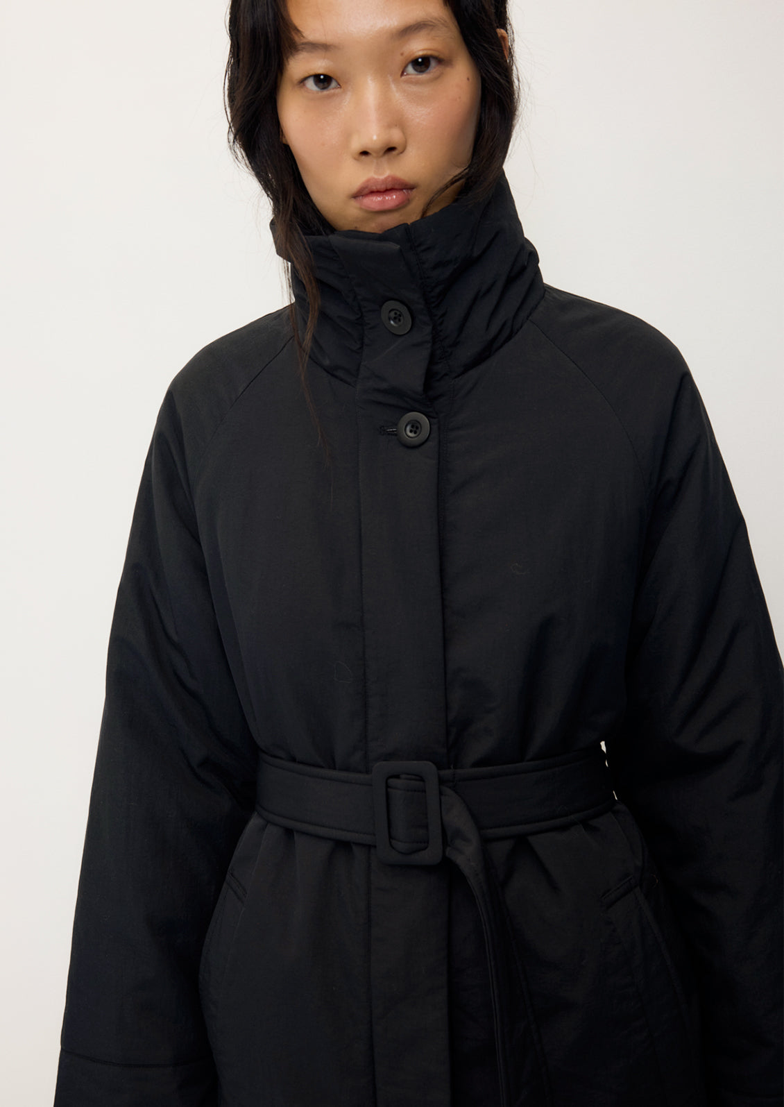 Tender Jacket in Black by Rita Row — close view of the buttoned funnel neck and the covered belt buckle