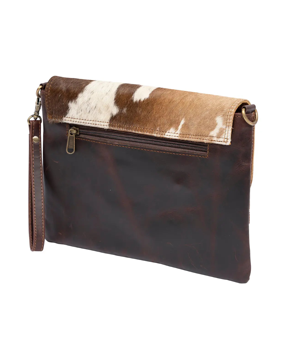 Brown leather clutch with cowhide pattern on a white background