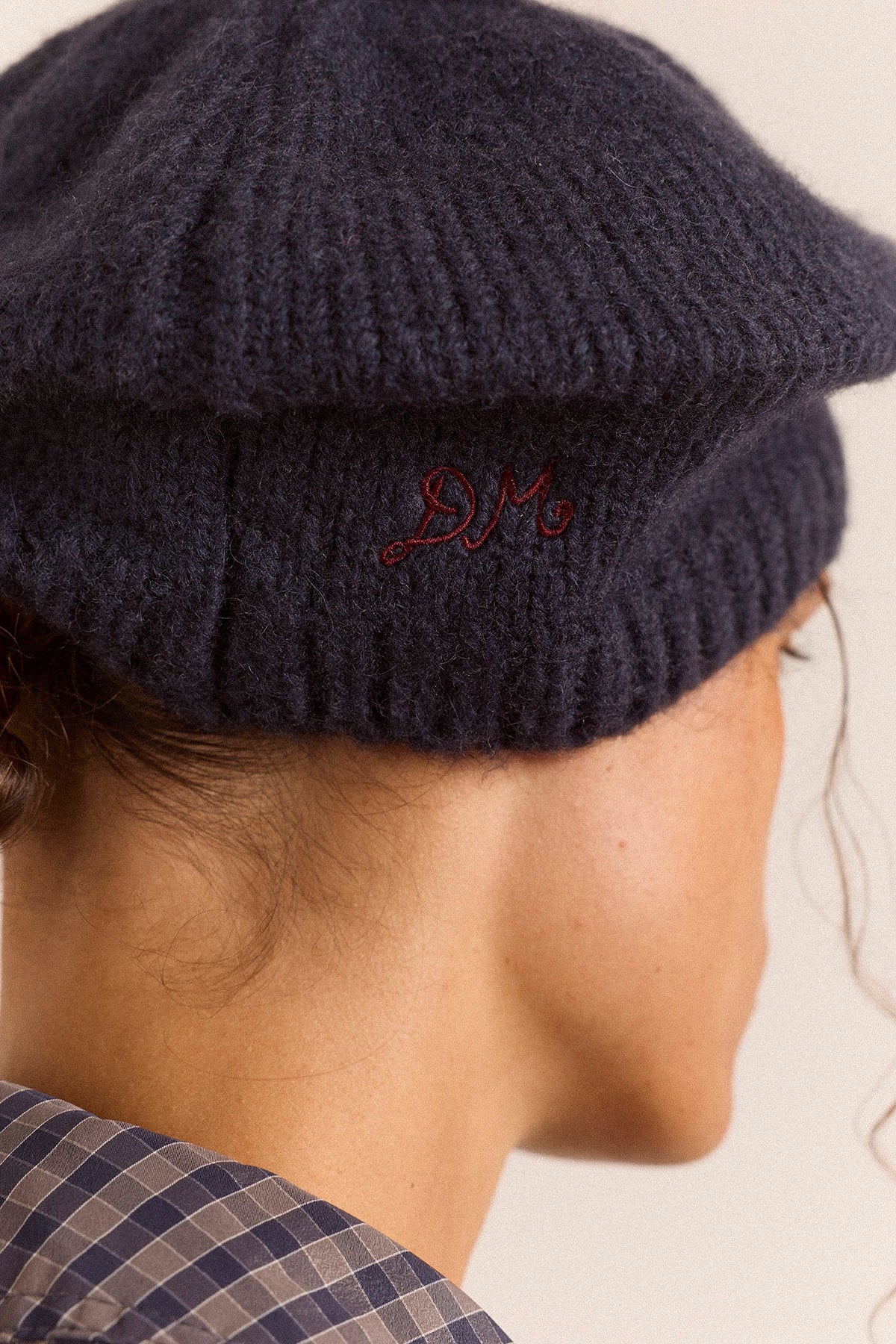 Knitted Pom Pom Beret in Navy, close view of the embroidered monogram
