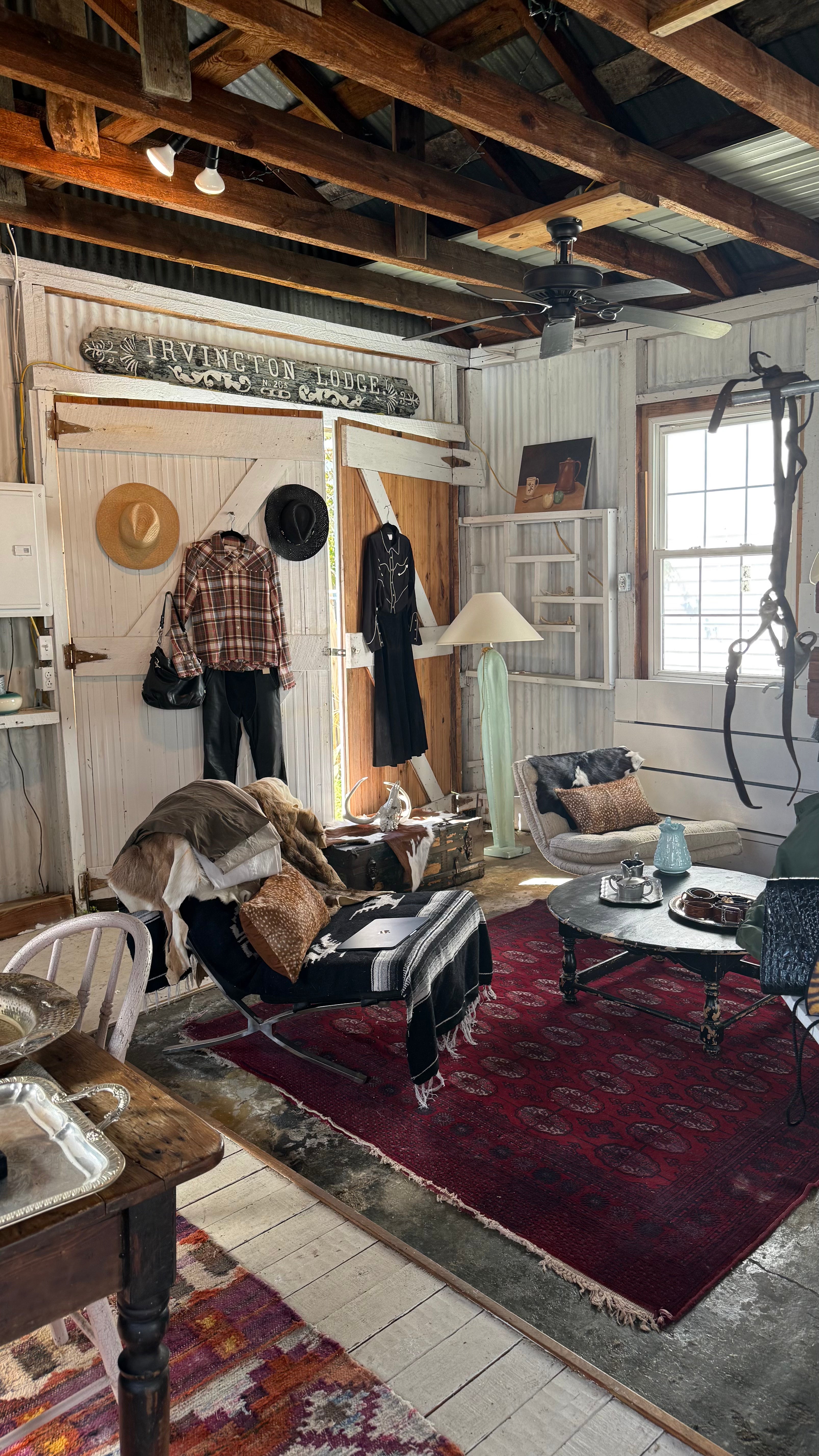 Western vintage inside the Dear Neighbor Irvington barn: rugs, hats, jackets and a leather chair