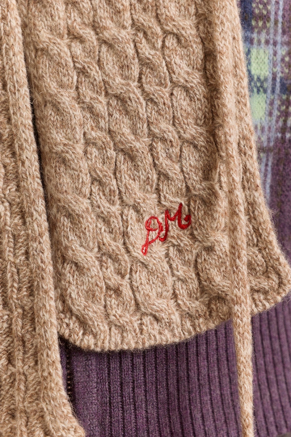 Hooded Pom Pom Scarf in Oatmeal Marl, detail of the cable knit and embroidery
